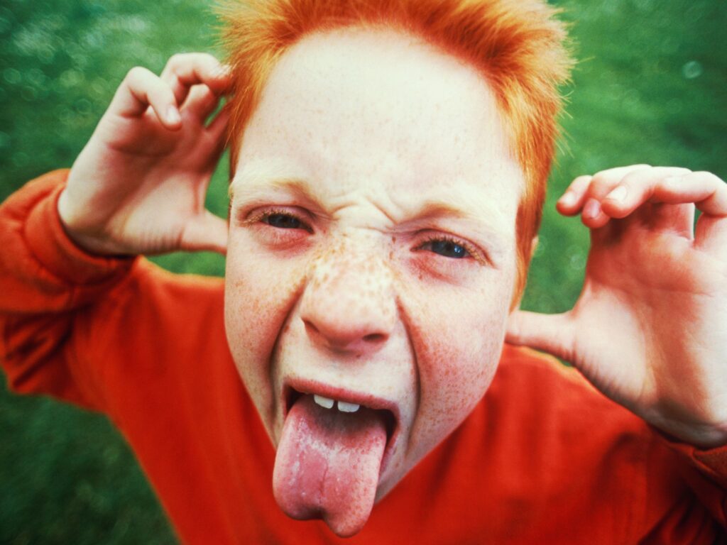 redhead boy sticking tongue out