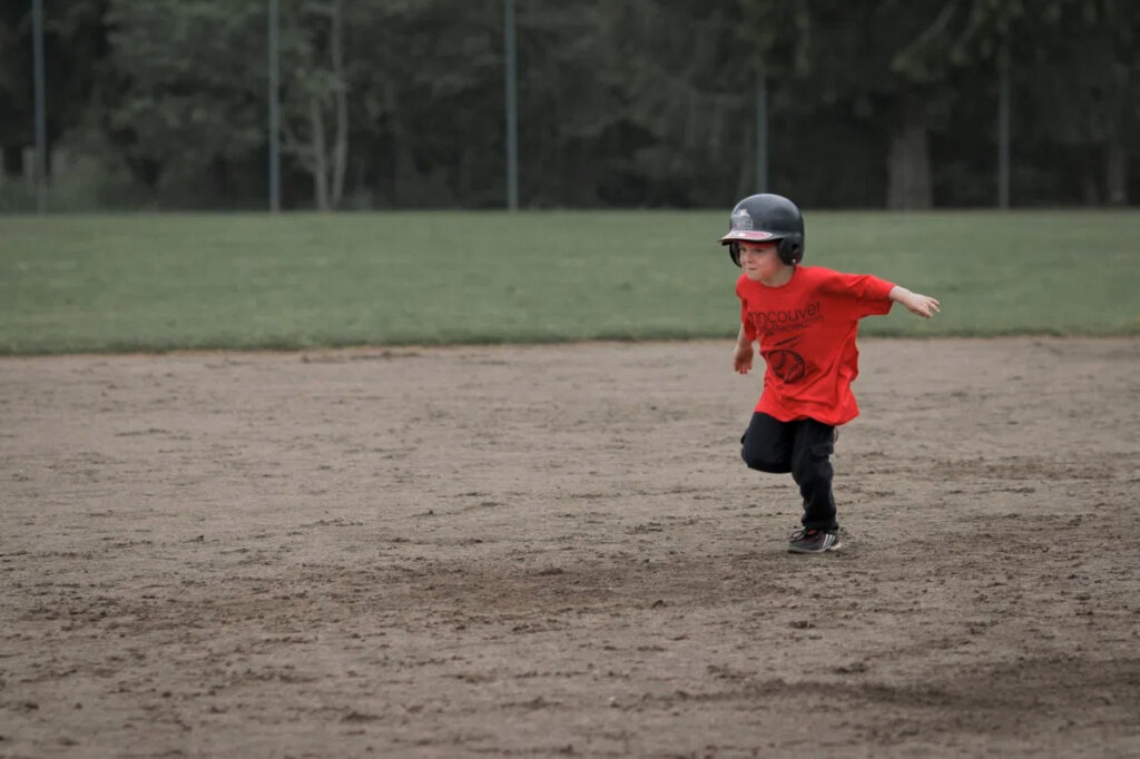 young boy running bases