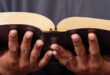 Young man's hands holding a Bible