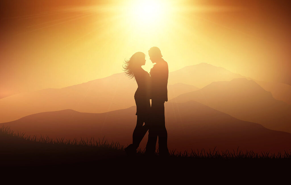 Couple embracing in front of sunset