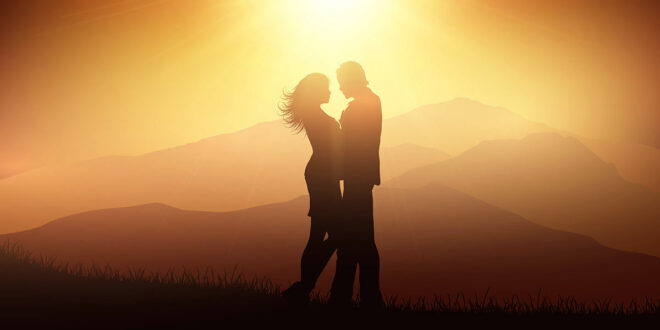 Couple embracing in front of sunset
