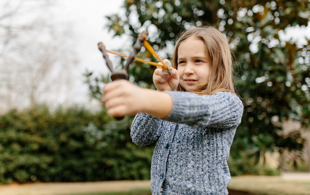 young girl using a slingshot