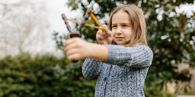 young girl using a slingshot