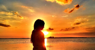 girl standing in front of sunset