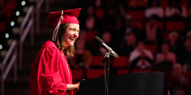 young woman laughs during graduation speech