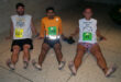 3 barefoot runners sitting after race