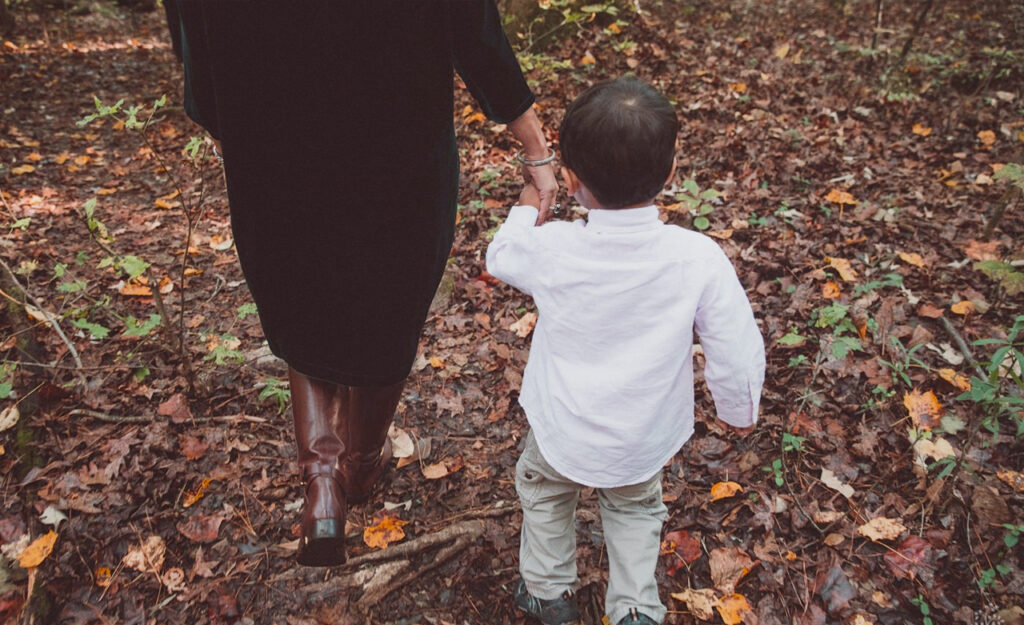 woman holding a young boy's hand