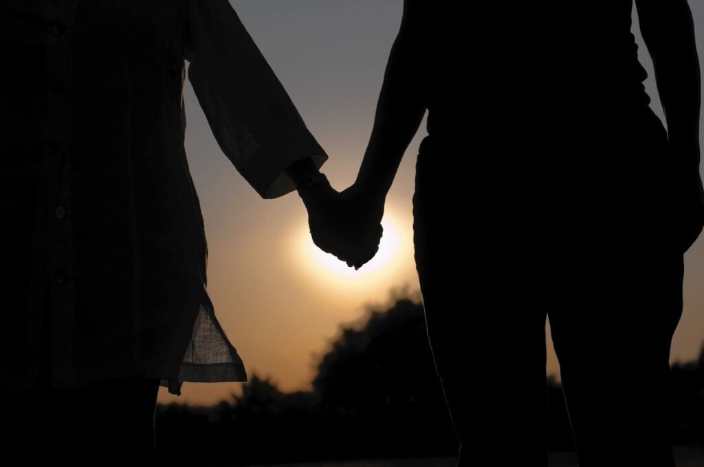 two adults holding hands in the moonlight