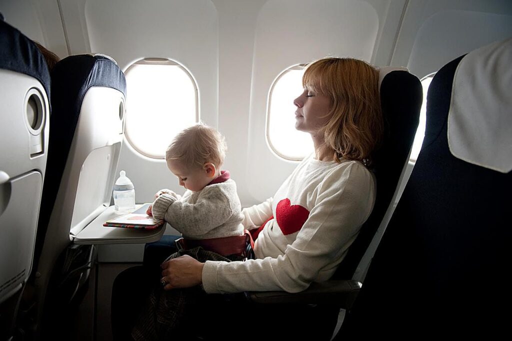 Mother and her baby at the window seat of an airplane